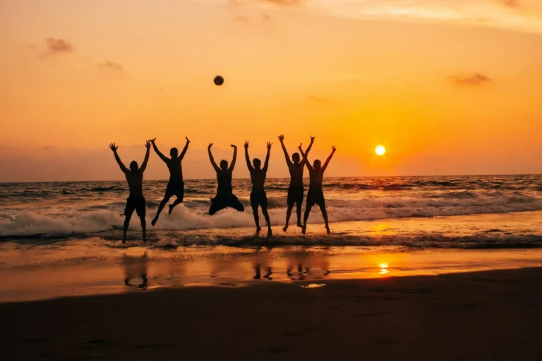 Friends jumping on the beach at sunset