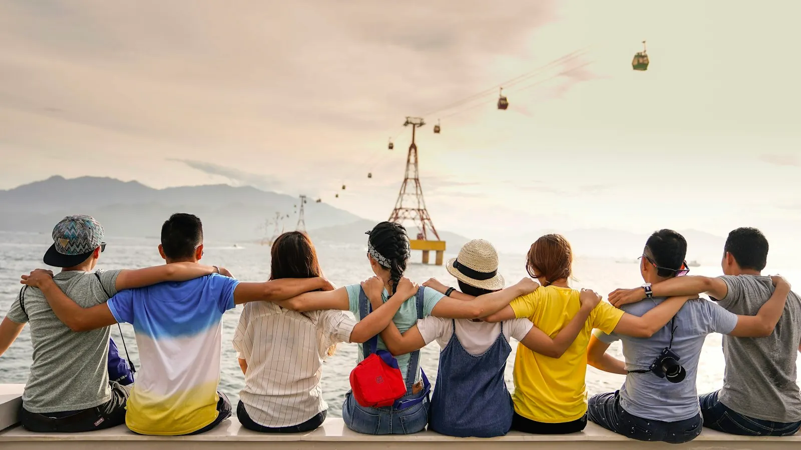 A group of friends sitting arm in arm, looking out over the view