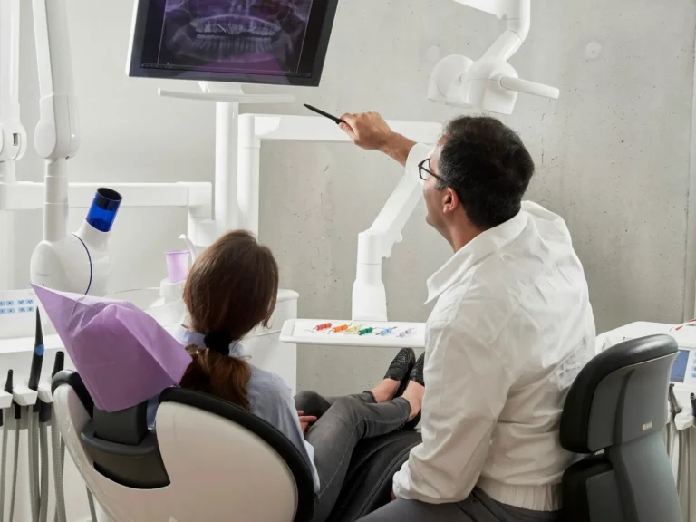 Dentist showing a patient her dental X-ray on a screen