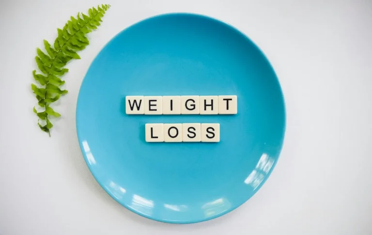 Blue plate with the words weight loss spelled in letter tiles